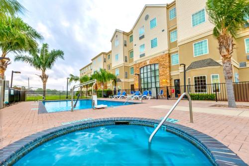 a swimming pool in front of a building at Staybridge Suites - Brownsville by IHG in Brownsville