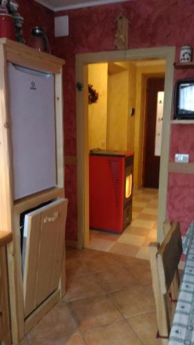a room with a kitchen with a counter and a refrigerator at Alloggio Castello Tesino in Castello Tesino