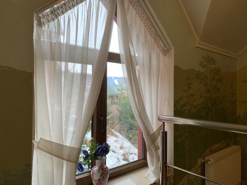 a window with white curtains in a room at Hotel Kalyna in Bukovel