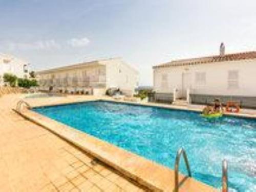 a large blue swimming pool in a building at Duplex Son Parc Vistas Costa Norte in Es Mercadal