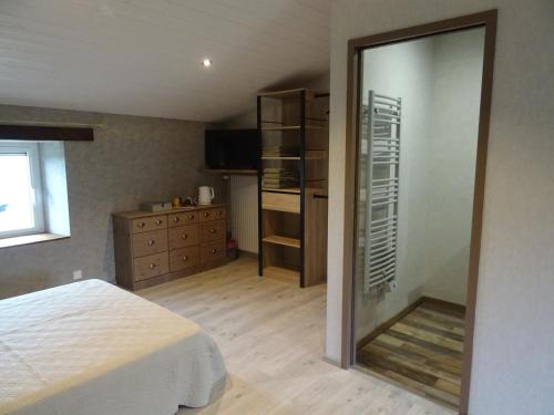a bedroom with a bed and a dresser and a mirror at La Lauriére in Treize-Vents