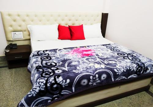 a bedroom with a black and white bed with red pillows at Hotel vinayak inn in Haridwār