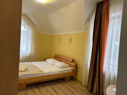 a small bedroom with a bed and a window at Hotel Kalyna in Bukovel