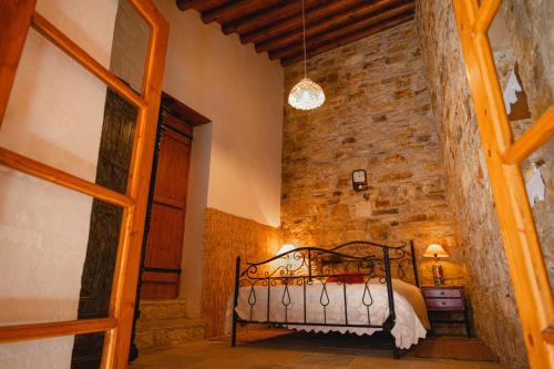 a bedroom with a bed in a room with a brick wall at Constantias stone houses in Lofou
