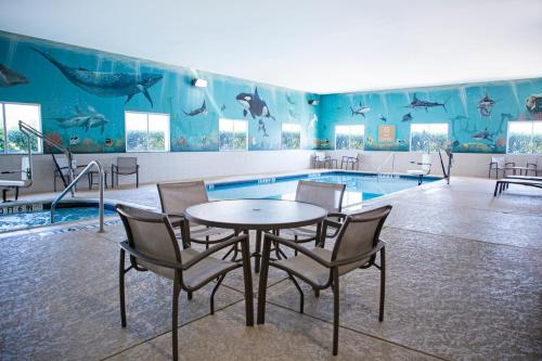 a dining room with a table and chairs in front of a pool at Candlewood Suites - Grand Prairie - Arlington by IHG in Grand Prairie