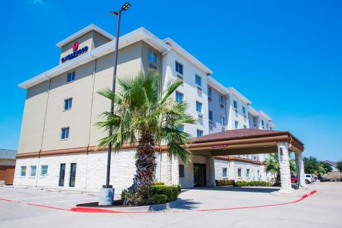 a hotel with a palm tree in front of it at Candlewood Suites - Grand Prairie - Arlington by IHG in Grand Prairie