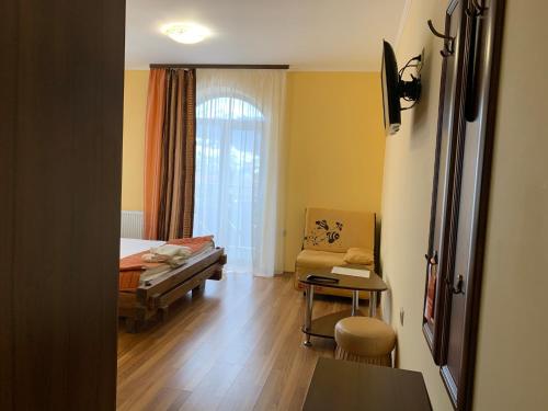 a room with a bed and a chair and a table at Hotel Kalyna in Bukovel