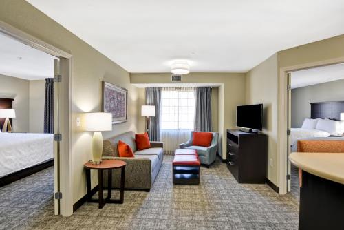 a hotel room with a bed and a living room at Staybridge Suites Mt Juliet - Nashville Area in Mount Juliet