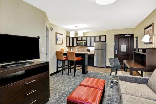 a living room with a couch and a tv and a kitchen at Staybridge Suites Mt Juliet - Nashville Area in Mount Juliet