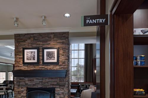 a lobby with a brick fireplace in a library at Staybridge Suites Austin Northwest by IHG in Austin
