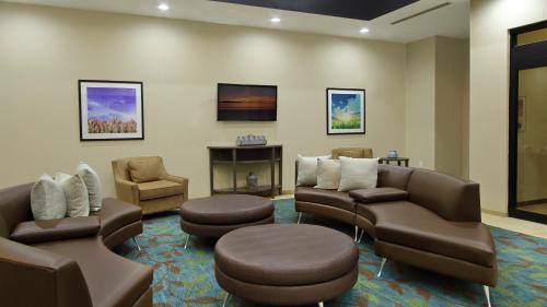 a waiting room with couches and chairs and a fireplace at Candlewood Suites - Frisco by IHG in Frisco