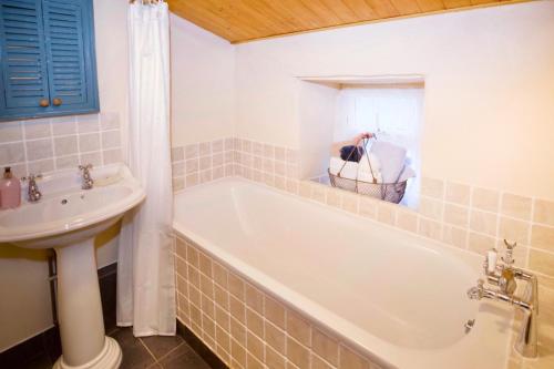 a bathroom with a tub and a sink at Vine Cottage in Penpillick