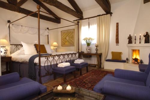 a bedroom with a canopy bed and chairs and a fireplace at Casa Encantada by Porta Hotels in Antigua Guatemala