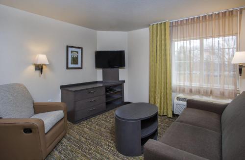a hotel room with a couch and a tv at Candlewood Suites Bowling Green by IHG in Bowling Green