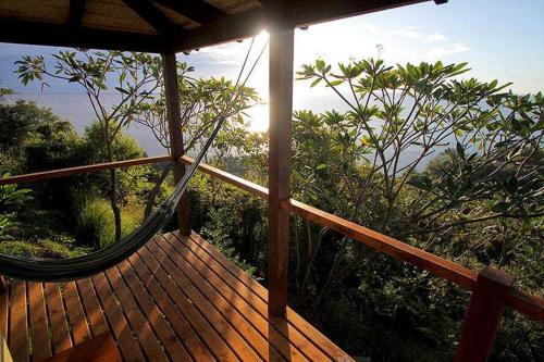 a hammock on a deck with the view of the ocean at Anamaya Resort in Montezuma