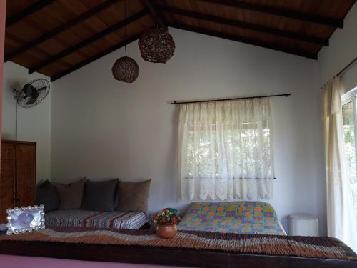 un dormitorio con una cama y una ventana en Chale da Lu, en Serra Grande