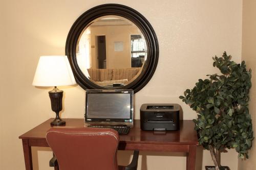 a desk with a laptop computer and a mirror at Candlewood Suites Champaign-Urbana University Area by IHG in Champaign