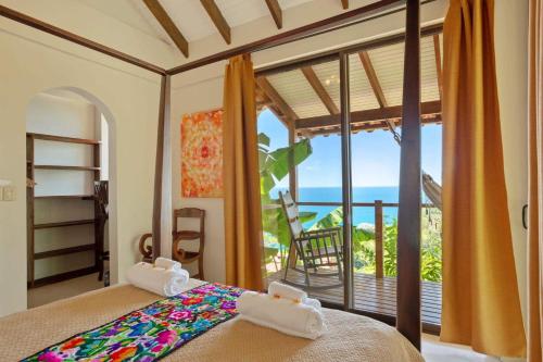 a bedroom with a bed with a view of the ocean at Anamaya Resort in Montezuma