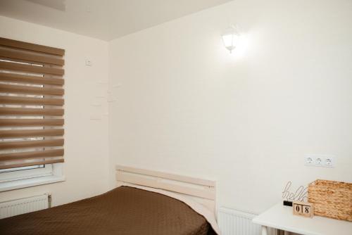 a white bedroom with a bed and a window at Apartments at Kontorska 10 in Kharkiv