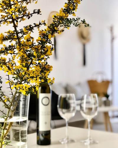 een fles wijn en twee wijnglazen op een tafel bij Klm House in Rhodos-stad