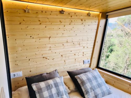 a room with a wooden wall and two pillows at Les Suites in Santa María de Palautordera