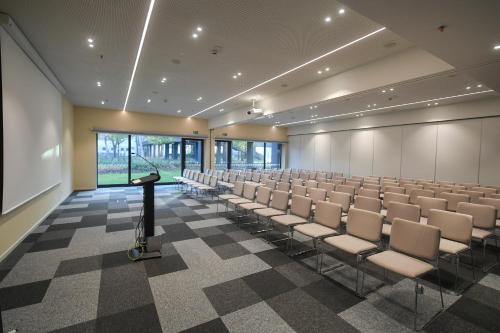 a conference room with chairs and a podium in the middle at Hunguest Hotel Sóstó in Nyíregyháza