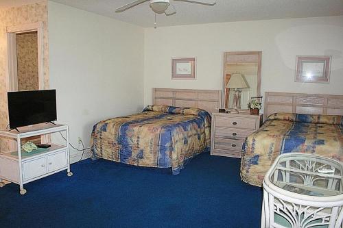 ein Hotelzimmer mit 2 Betten und einem TV in der Unterkunft 805L home in Calabash