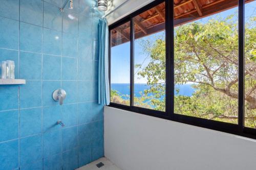 a bathroom with a shower with a large window at Anamaya Resort in Montezuma