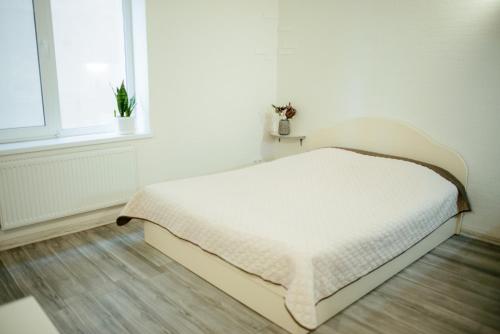 a white bed in a room with a window at Apartments at Kontorska 10 in Kharkiv