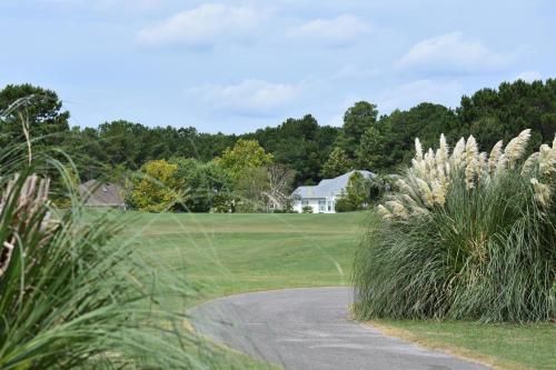 a golf course with a house and some grass at Brunswick Plantation Villa 1005 in Calabash