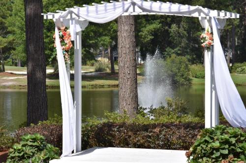 a white arch over a pond with a fountain at Brunswick Plantation Villa 1005 in Calabash