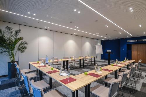 a conference room with long tables and chairs at Hunguest Hotel Sóstó in Nyíregyháza