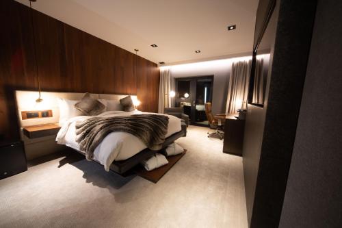a bedroom with a large bed and a desk at Cave Hotel & Golf Resort in Faversham