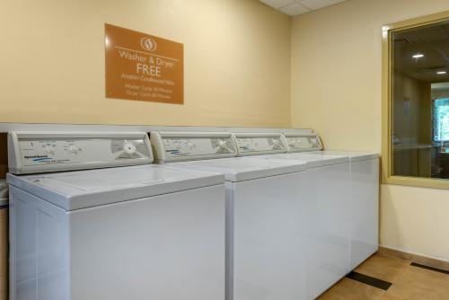 a washing machine in a room with a sign on the wall at Candlewood Suites Fort Myers/Sanibel Gateway by IHG in Fort Myers