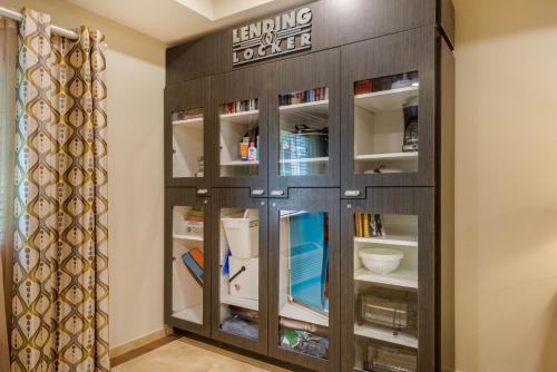 a book shelf with a sign on it in a room at Candlewood Suites Fort Myers/Sanibel Gateway by IHG in Fort Myers