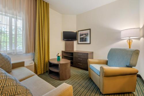 a hotel room with a couch and a chair at Candlewood Suites Fort Myers/Sanibel Gateway by IHG in Fort Myers