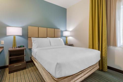 a bedroom with a large bed and a window at Candlewood Suites Fort Myers/Sanibel Gateway by IHG in Fort Myers