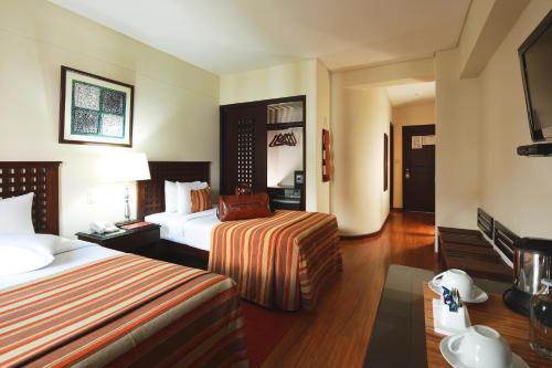 a hotel room with two beds and a table at San Agustin El Dorado in Cusco