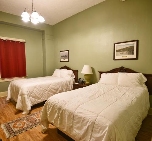 two beds in a room with green walls at Shawnee Inn and Golf Resort in East Stroudsburg