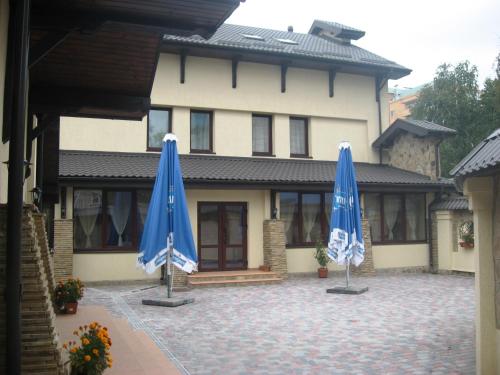 two blue umbrellas in front of a house at Shato Paradis Hotel in Irpin'