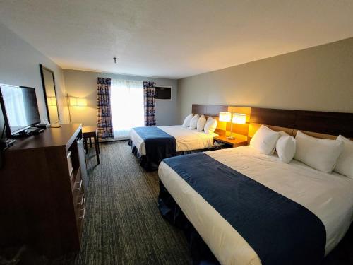 a hotel room with two beds and a flat screen tv at Hampton Village Inn in Hampton