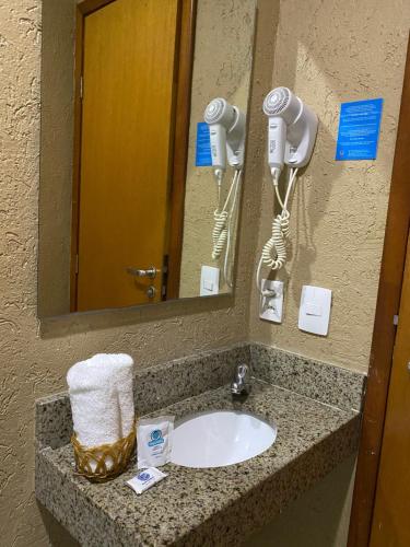a bathroom sink with a hair dryer and a mirror at Hotel Aquarius in Fortaleza