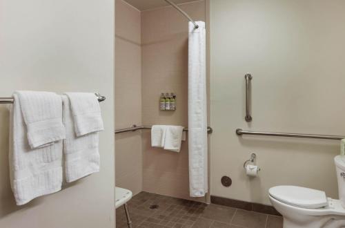 a bathroom with a toilet and a shower with towels at Candlewood Suites - Brighton, an IHG Hotel in Brighton