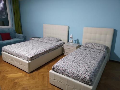 two twin beds in a room with a chair and a bed sqor at New Life in Mestre