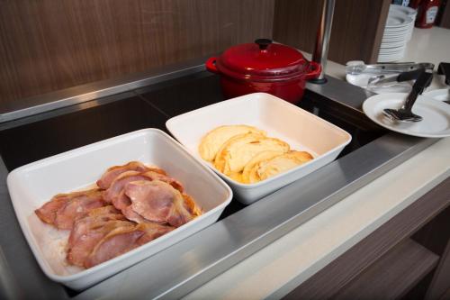 twoperate dishes of food on a kitchen counter at Staybridge Suites Birmingham by IHG in Birmingham