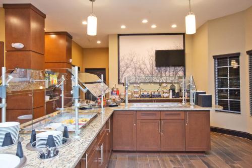 a large kitchen with wooden cabinets and a large window at Staybridge Suites Austin South Interstate Hwy 35 by IHG in Austin