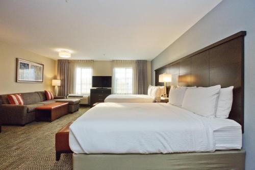 a hotel room with a large bed and a couch at Staybridge Suites Austin South Interstate Hwy 35 by IHG in Austin