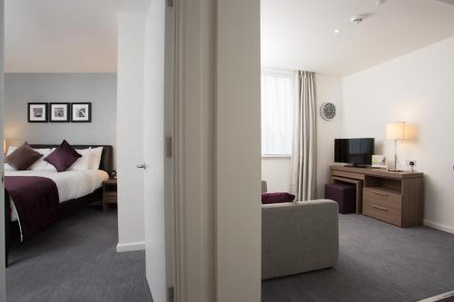 a hotel room with a bed and a television at Staybridge Suites Birmingham by IHG in Birmingham