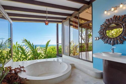 a bathroom with a large tub and a sink at Anamaya Resort in Montezuma