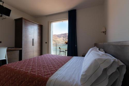 a bedroom with a bed and a window with a view at Locanda del Lago Rosmunda in Clusane sul Lago